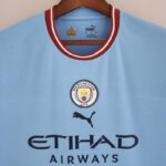Camiseta Manchester City Primera Equipación 2022-2023 Versión Fan pecho