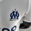 Camiseta Olympique de Marsella versión jugador local 2022-2023 escudo