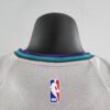 camiseta hornets gris cuello anterior con borde celeste, axul ynegro y etiqueta nba