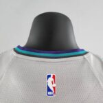 camiseta hornets gris cuello anterior con borde celeste, axul ynegro y etiqueta nba