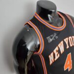 camiseta negra new york knicks diseño lateral con bordes naranja y azul y el logo