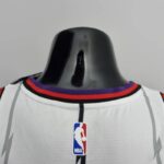 camiseta raptors blanca cuello anterior con bordes azules y rojoj ylogo nba