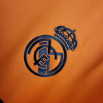camiseta real madrid naranja escudo