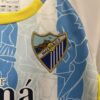 Conjunto Niño Málaga Primera Equipacion 2024-2025 logo