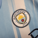 conjunto-niño-manchester-city-primera-equipacion-2025-2026-escudo