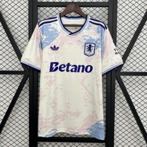 Camiseta Aston Villa Tercera Equipación 2025-2026: Color base: Predomina el blanco, brindando un aspecto limpio y elegante a la camiseta. Diseño marmoleado: Presenta un patrón en tonos rosa y azul claro, creando un efecto visual moderno y atractivo. Detalles en azul: Los bordes del cuello, las mangas y los logotipos destacan en azul intenso, aportando contraste y personalidad. Escudo del club: El emblema del Aston Villa aparece en el pecho izquierdo, mostrando el orgullo y la tradición del equipo. Tecnología de fabricación: Confeccionada con tejido transpirable y ligero para comodidad y rendimiento en el juego. Corte y estilo: Ajuste deportivo que ofrece libertad de movimiento y estilo tanto para jugadores como para aficionados. Temporada oficial: Forma parte de la colección 2025-2026, combinando diseño innovador y pasión por el club. Detalles del producto Color: Blanco Diseño: Camiseta aston villa tercera equipacion 2024-2026 Escudo: Incluye el escudo del Club. Personalización: Puede incluir el nombre y el número de los jugadores estrella. Material: De alta calidad para mayor comodidad y durabilidad. Tallas: Disponible en varias tallas para adaptarse a diferentes cuerpos y edades (S,M,L,XL,2XL) Precio: €34,99 Precio Rebajado: €24,99 Cuidado de la camiseta Lava la camiseta a mano o en lavadora con agua fría. No uses blanqueadores ni productos químicos fuertes. No planchar sobre los estampados (escudo, patrocinador, numero y nombre). No lavar en seco. si es posible, lava la camiseta del revés para proteger el diseño y la personalización. No utilizar secadora, ya que puede dañar las fibras del tejido. No retuerzas ni estrujes la camiseta, cuélgala o dóblala suavemente para guardarla Secar la camiseta al aire libre preferiblemente en un lugar con sombra para evitar la decoloración Evite exponer la camiseta a la luz directa del sol durante largos periodos de tiempo para disfrutar la camiseta como el dia en que la recibes Explora la colección completa de camisetas [products limit="12" category="aston-villa"] Ver más Explora la colección completa del conjunto de niños y bodys [products limit="12" category="ninos" tag="aston-villa"]