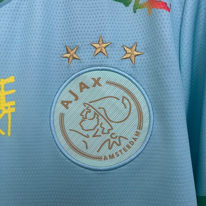 camiseta-ajax-bob-marley-edicion-especial-celeste-2025-2026-escudo