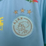 camiseta-ajax-bob-marley-edicion-especial-celeste-2025-2026-escudo