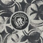 camiseta-manchester-city-calentamiento-segunda-equipacion-2025-2026-escudo