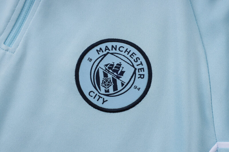 chandal-manchester-city-cremallera-baja-celeste-2025-2026-escudo