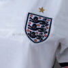 camiseta-inglaterra-primera-equipacion-mujer-mundial-2026-escudo